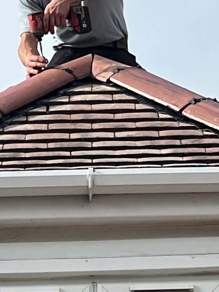 This is a photo of one of the operatives of Shirebrook Roofing Repairs installing new ridge tiles