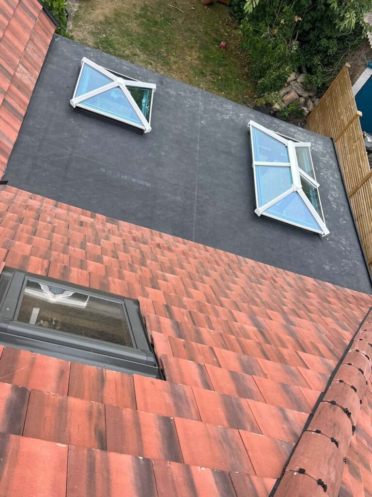 This is a photo taken from the roof ridge looking down a tiled pitched roof on to a flat roof. Works carried out by Shirebrook Roofing Repairs